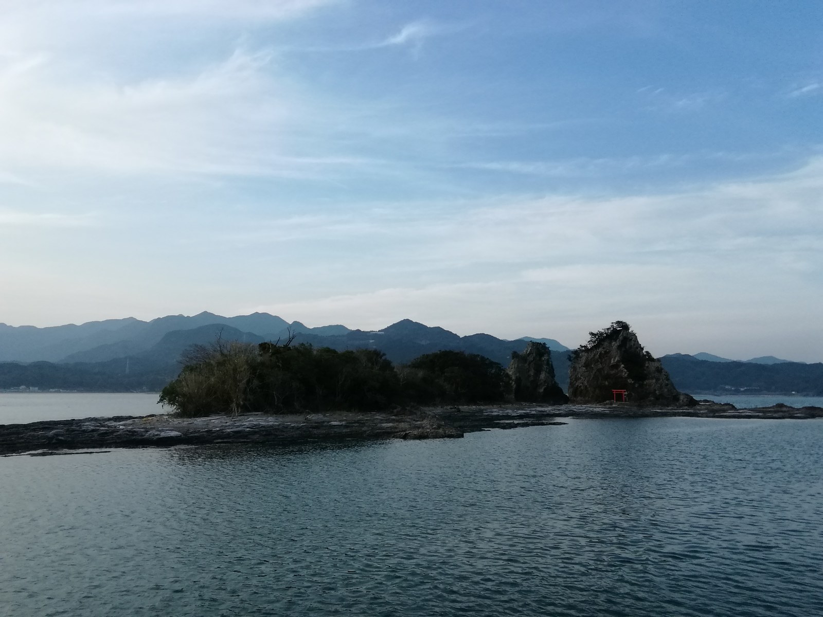 朱色の鳥居が立つ弁天島と夕方の海